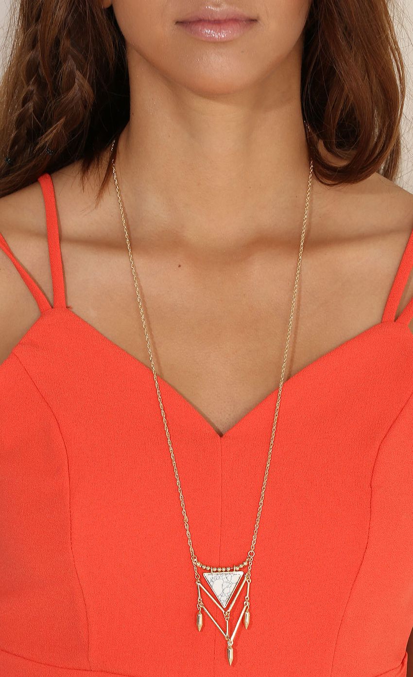 Picture Gold geometric long necklace. Source: https://media-img.lucyinthesky.com/data/Apr15_1/850xAUTO/0Y5A4452.JPG