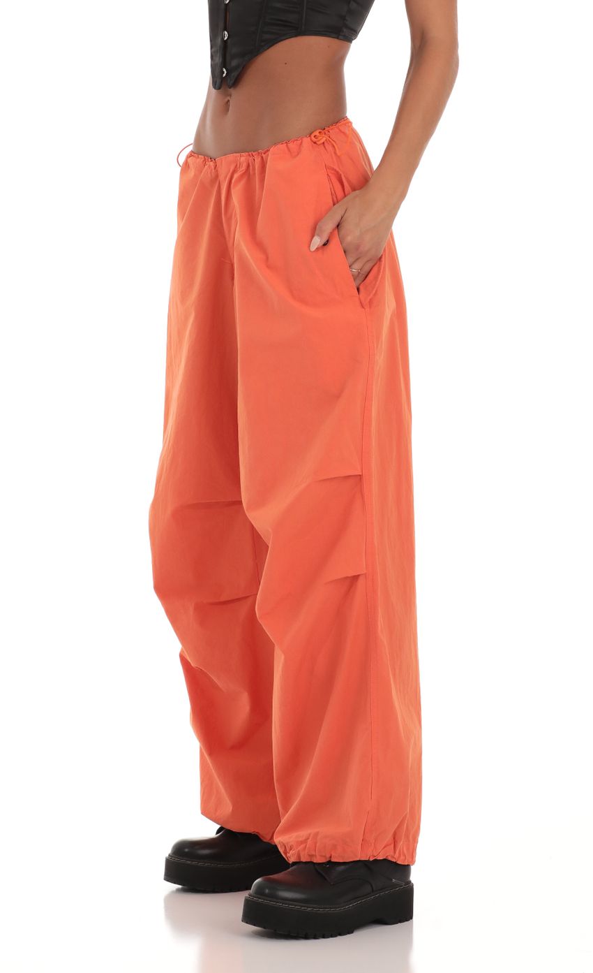 Picture Tyche Wide Leg Parachute Pants in Orange. Source: https://media-img.lucyinthesky.com/data/Aug23/850xAUTO/5332b0d8-a273-46e8-a649-0c440220359e.jpg