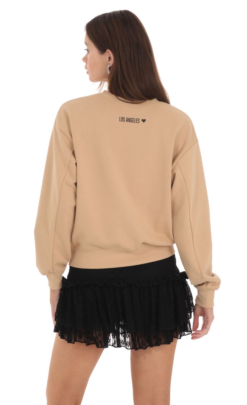 Picture Lucy in the Sky Crew Jumper in Brown. Source: https://media-img.lucyinthesky.com/data/Feb24/850xAUTO/a72ed4d8-bc51-4c90-8a46-02d3dc260a73.jpg