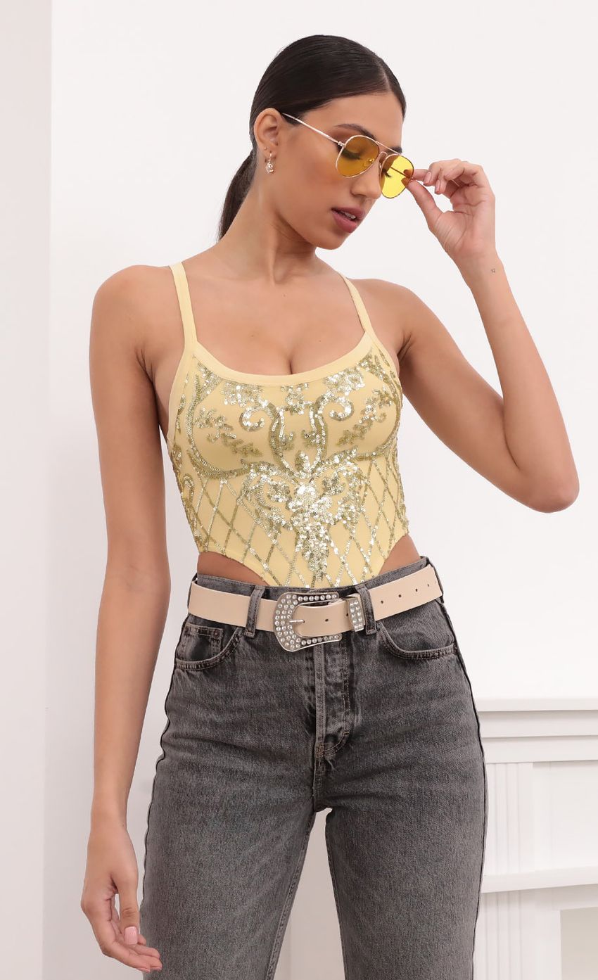 Picture Ciera High-Cut Bodysuit in Gold Sequins. Source: https://media-img.lucyinthesky.com/data/Mar21_1/850xAUTO/1V9A6017L.JPG