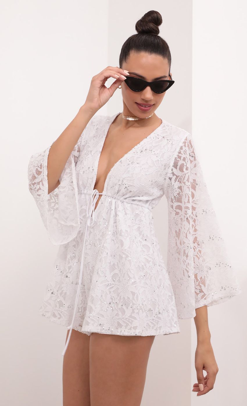 Picture Kadee Bell Sleeve Romper in White Sequined Lace. Source: https://media-img.lucyinthesky.com/data/Mar21_2/850xAUTO/1V9A5590.JPG