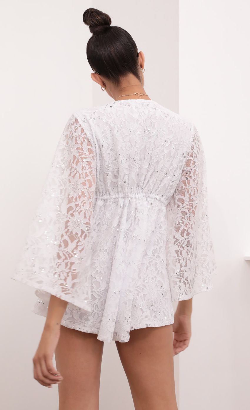 Picture Kadee Bell Sleeve Romper in White Sequined Lace. Source: https://media-img.lucyinthesky.com/data/Mar21_2/850xAUTO/1V9A5617.JPG