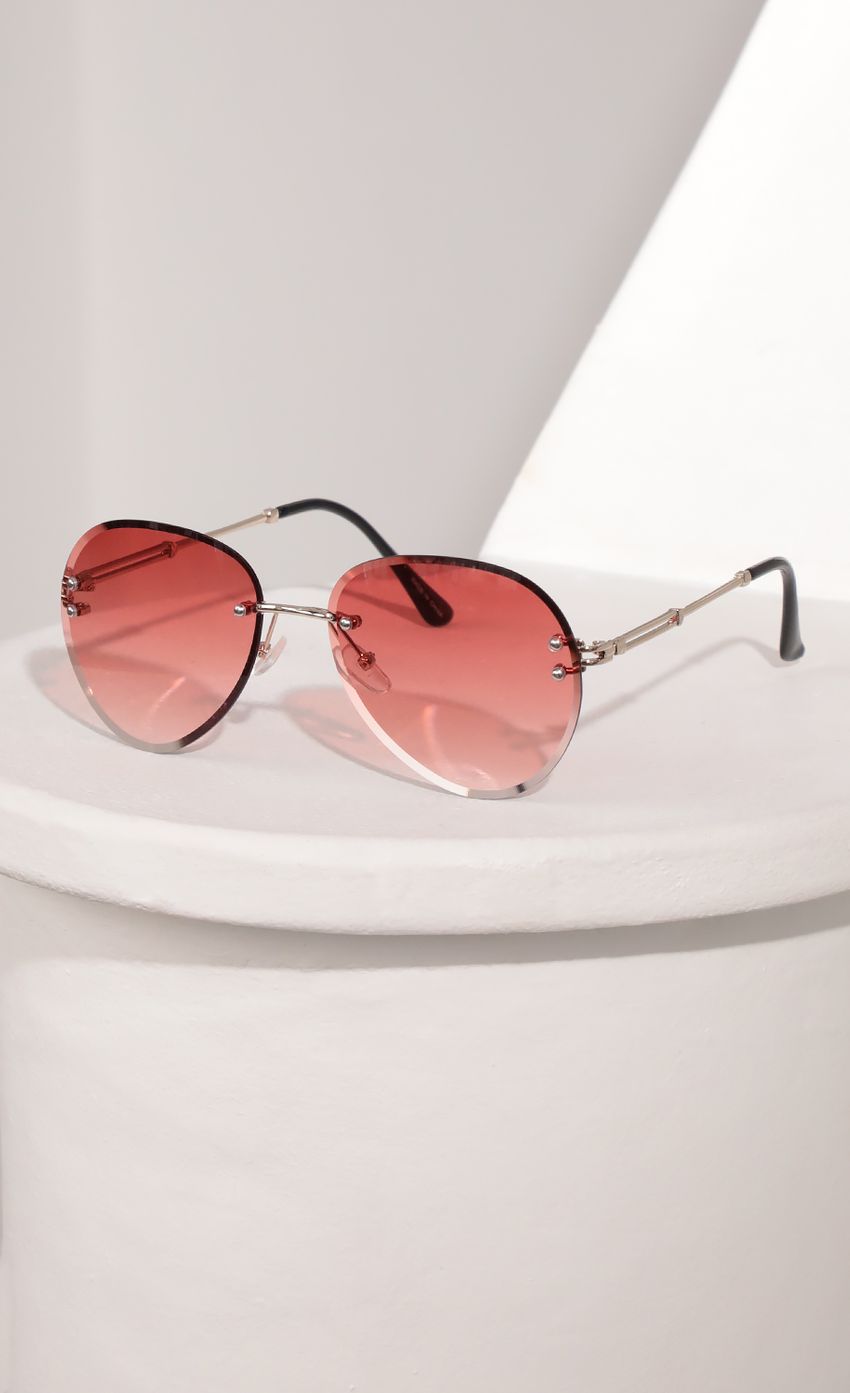 Picture Rimless Aviator-Inspired Sunglasses in Coral. Source: https://media-img.lucyinthesky.com/data/Mar21_2/850xAUTO/AT2A9381.JPG