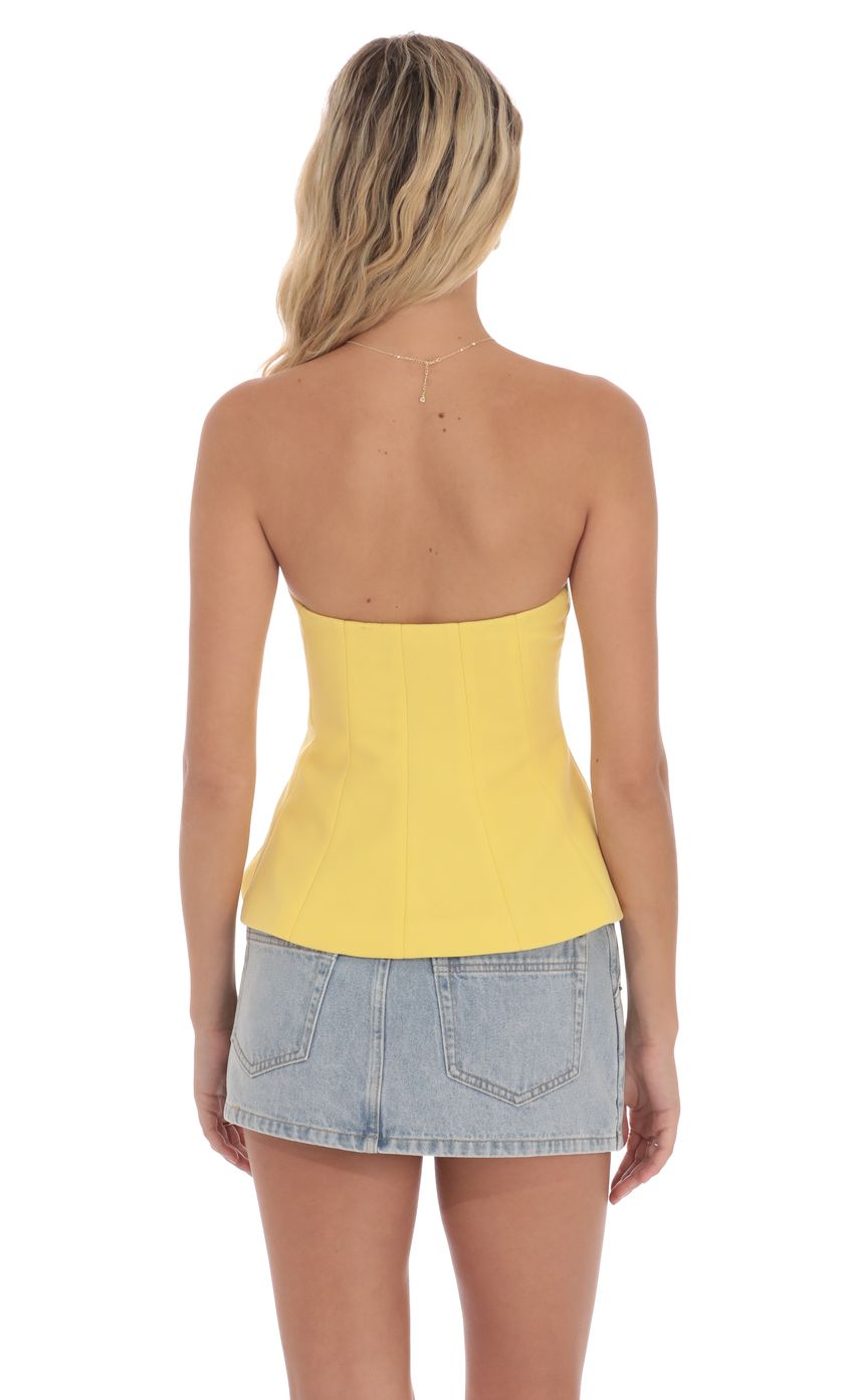 Picture Strapless Peplum Top in Yellow. Source: https://media-img.lucyinthesky.com/data/product-media/850xAUTO/122c461b-6df4-4bb7-8ec1-2819f462e5b4.jpg