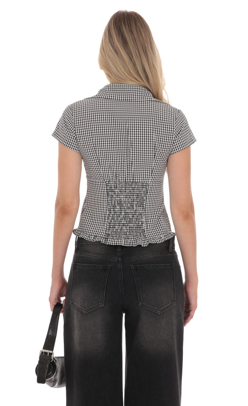 Picture Button-Up Ruffle Top in Black Gingham. Source: https://media-img.lucyinthesky.com/data/product-media/850xAUTO/1e0aedfe-cc1d-4adb-af14-178d3caad539.jpg