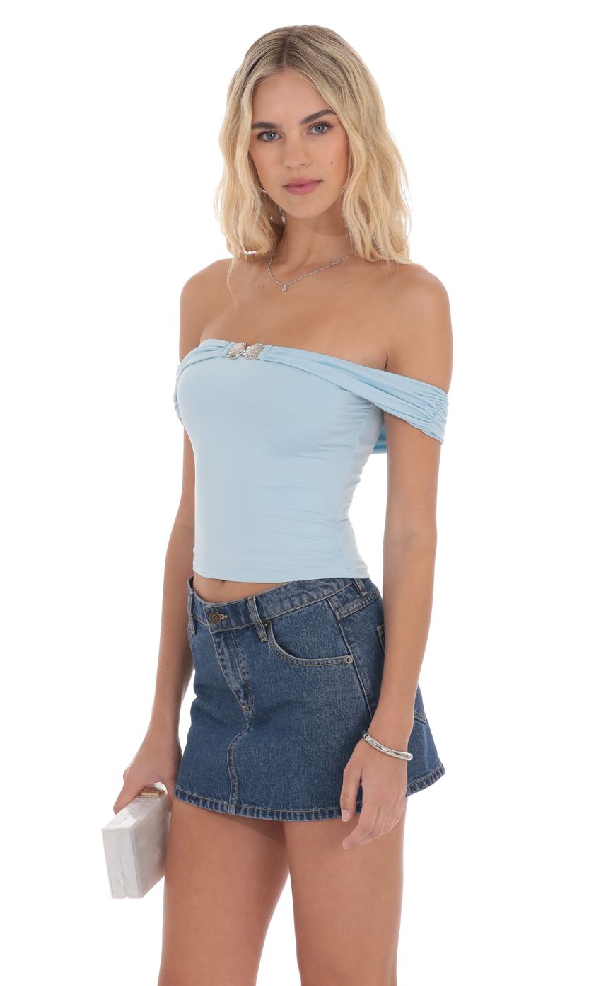 Picture Embellished Off Shoulder Top in Light Blue. Source: https://media-img.lucyinthesky.com/data/product-media/850xAUTO/82bc6ce8-a534-456c-b5d2-6d2d3379b3f0.jpg