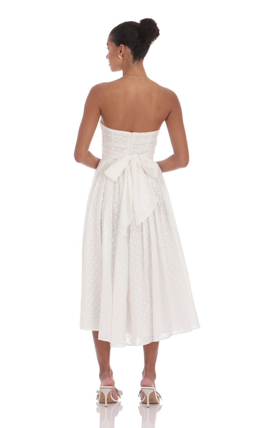 Picture Floral Back Bow Midi Dress in White. Source: https://media-img.lucyinthesky.com/data/product-media/850xAUTO/cb9b6b62-ca6a-41a5-814f-8626a79d3395.jpg