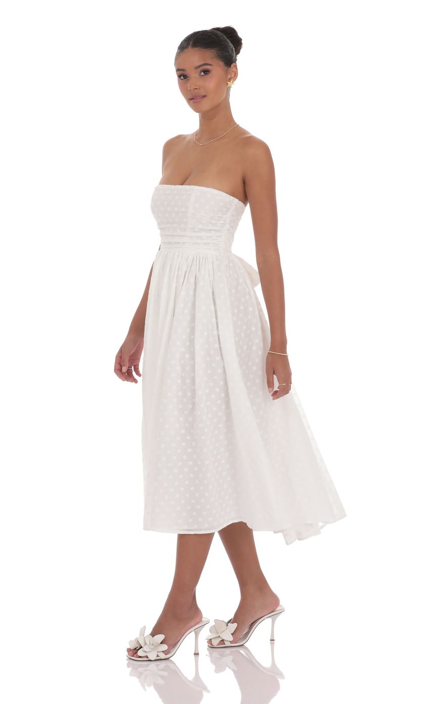 Picture Floral Back Bow Midi Dress in White. Source: https://media-img.lucyinthesky.com/data/product-media/850xAUTO/e5605a08-8ee3-46fa-87a7-4eb242a9da19.jpg